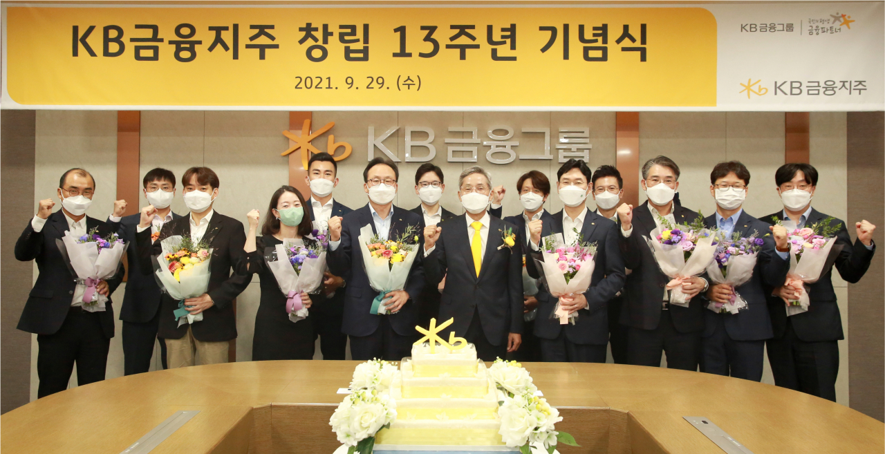 윤종규(가운데) KB금융그룹 회장이 29일 서울 여의도 국민은행 본점 신관에서 개최된 그룹 창립 13주년 행사에서 장기근속 직원들에게 공로패를 전달한 뒤 기념사진을 찍고 있다.