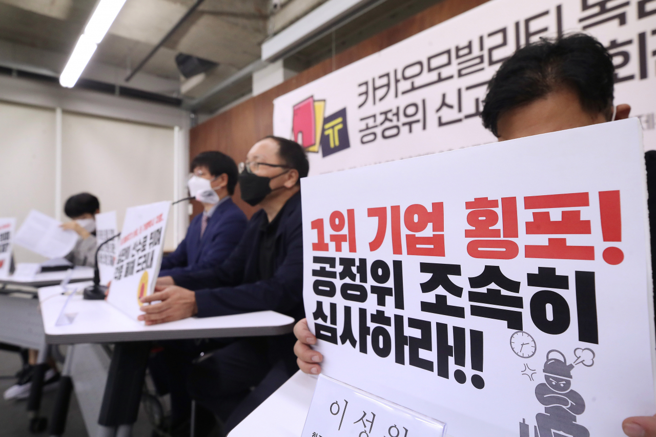 29일 오전 서울 종로구 참여연대에서 열린 '카카오모빌리티 독점 갑질 공정위 신고 기자회견'에서 참석자들이 손팻말을 들고 있다. [연합]