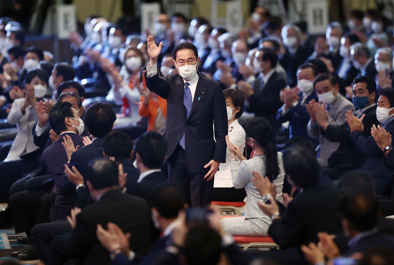 기시다 후미오(岸田文雄·가운데) 전 자민당 정무조사회장이 지난 29일 일본 도쿄(東京) 한 호텔에서 열린 집권 자민당 총재 선거에서 당선된 후 자민당 소속 의원들의 박수에 손을 흔들며 답하고 있다. [AFP]