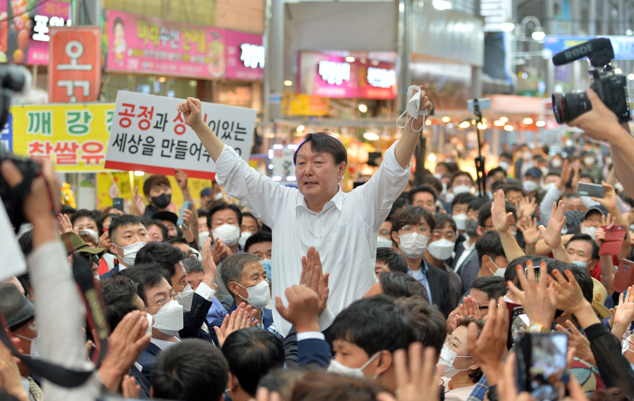 지난 17일 경북 포항 죽도시장에서 국민의힘 대선 경선 예비후보인 윤석열 전 검찰총장이 지지자들에게 두 손을 번쩍 들어 자신감을 내비치고 있다. [연합]