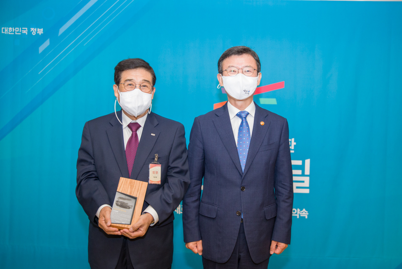 광화문 정부서울청사에서 30일 개최된 ‘이달의 한국판뉴딜’ 감사패 수여식에서 문성혁 해양수산부장관(사진 우측)과 배재훈 HMM 대표이사가 기념촬영을 하고 있다.[HMM 제공]