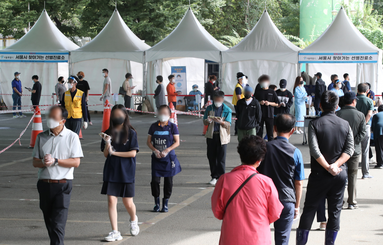 국내 신종 코로나바이러스 감염증(코로나19) 확산세가 좀체 잦아들지 않는 가운데 30일 오전 서울 송파구 가락시장 '서울시 찾아가는 선별진료소'에서 검사를 받으려는 시민들이 줄을 서 있다.[연합]