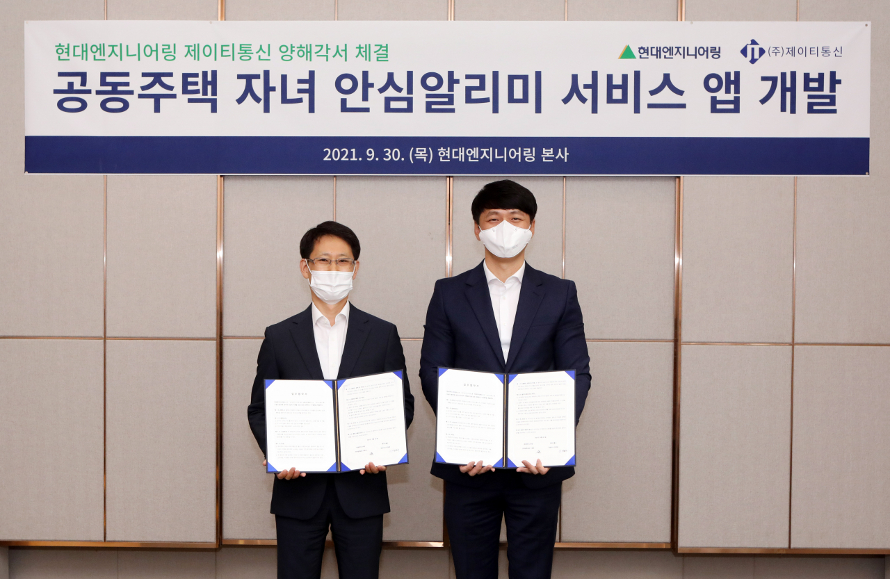 현대엔지니어링 이동호 건축설계실장(왼쪽)과 제이티통신 이정태 대표가 지난달 30일 서울 종로구 현대엔지니어링 계동 사옥에서 공동주택 자녀 안심알리미 서비스 애플리케이션 개발 양해각서(MOU)를 맺은 뒤 기념촬영을 하고 있다. [현대엔지니어링 제공]