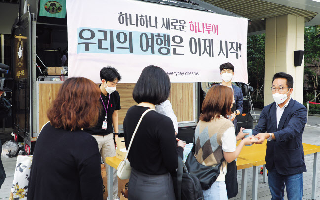 하나투어가 전 직원 정상근무를 시작한 1일 오전 종로구 본사 앞에서 김진국 대표가 출근하는 직원들에게 커피와 간식을 주고 있다. 코로나19 사태로 지난해 4월부터 필수 인력 외 직원을 상대로 유·무급 휴직을 시행한 하나투어는 이날부터 정상근무를 시작했다. [연합]