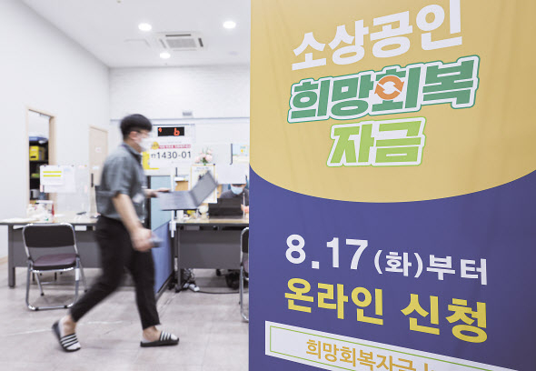 10월말부터 시작되는 소상공인 손실보상과 관련해 올해 편성된 예산은 1조원뿐이지만, 고강도 사회적 거리두기로 인한 피해액이 증가하며 보상액도 늘어나 재정부담이 예상된다. 사진은 8월 30일 서울 종로구 소상공인시장진흥공단 서울중부센터에 게시된 5차 재난지원금인 소상공인 희망 회복자금 안내. [연합]