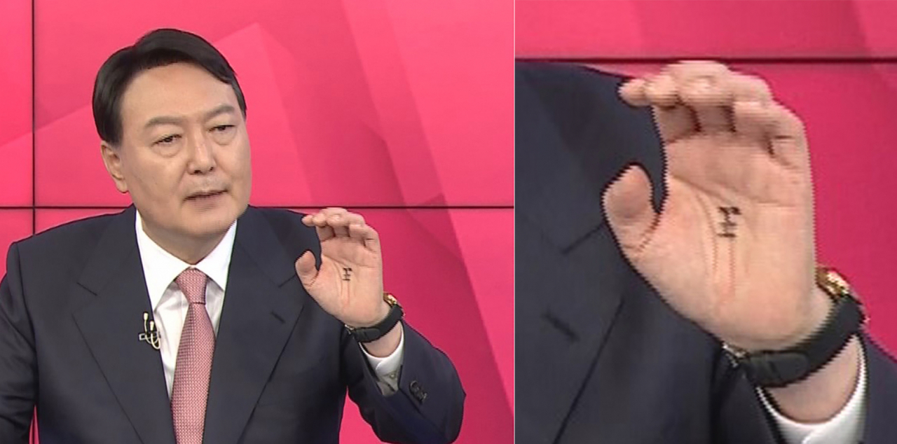 국민의힘 대권주자인 윤석열 전 검찰총장이 TV토론회 당시 손바닥 한가운데에 '왕(王)'자를 그려놓은 장면이 카메라에 포착됐다. [연합]