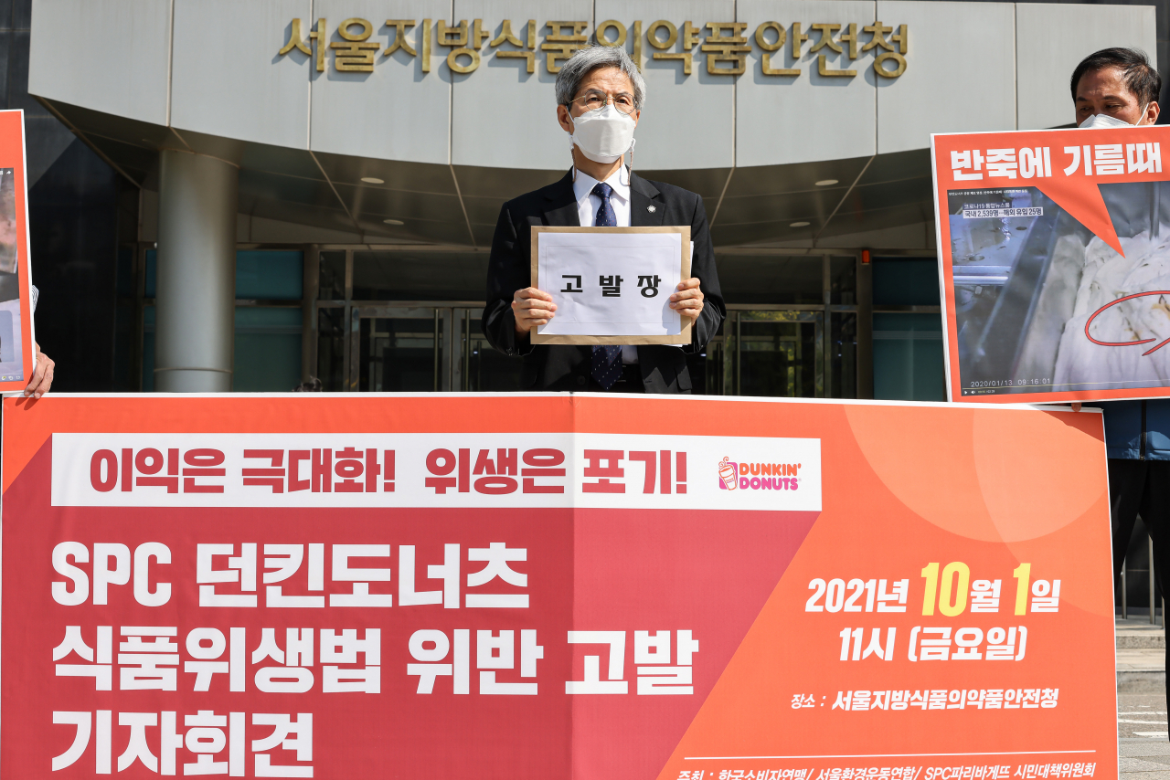 1일 오전 서울 양천구 서울지방식품의약품안전청 앞에서 열린 ‘SPC 던킨도너츠 식품위생법 위반 고발’ 기자회견에서 대책위 공동대표인 권영국 변호사(가운데)가 SPC를 고발하는 고발장을 들고 있다. [연합]