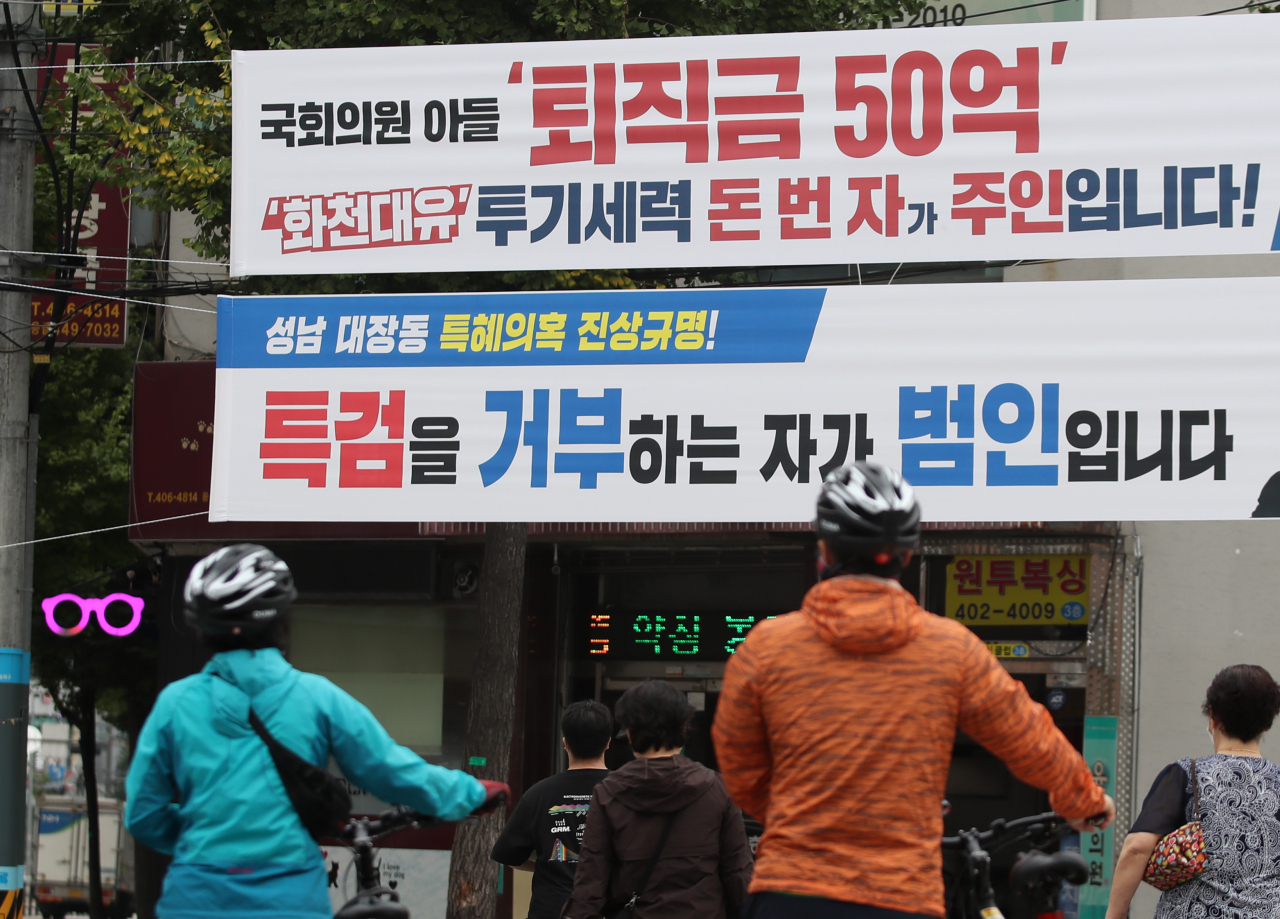 4일 서울 송파구의 한 도로에 더불어민주당과 국민의힘이 각각 내건 '화천대유' 관련 현수막이 나란히 보인다. 연합뉴스