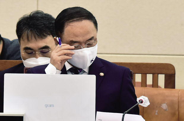홍남기 경제부총리가 5일 서울 여의도 국회에서 열린 국회 기획재정위원회의 기획재정부 국정감사에 출석, 안경을 고쳐쓰고 있다. 이날 기재부 국감은 국민의힘 의원들이 국감장에 설치한 대장동 개발사업과 관려한 인쇄물의 제거를 둘러싸고 여야간 갈등이 빚어지면서 개의가 지연되는 등 파행을 겪었다. [연합]