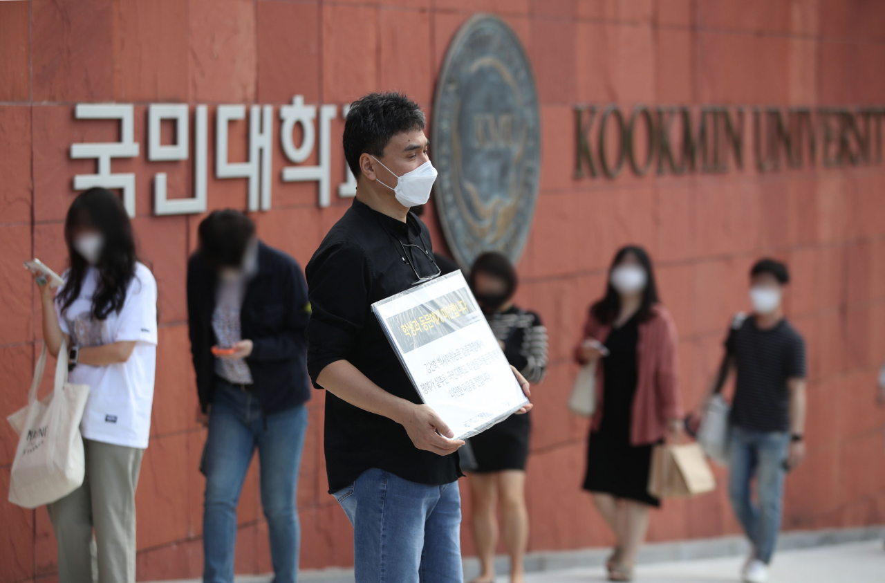 ‘국민대학교의 학문적 양심을 생각하는 교수들’ 소속의 한 교수가 지난 9월 17일 오전 서울 성북구 국민대학교 정문 앞에서 윤석열 전 검찰총장 부인 김건희 씨의 박사 논문 재조사를 촉구하는 1인 시위를 하고 있다. [연합]
