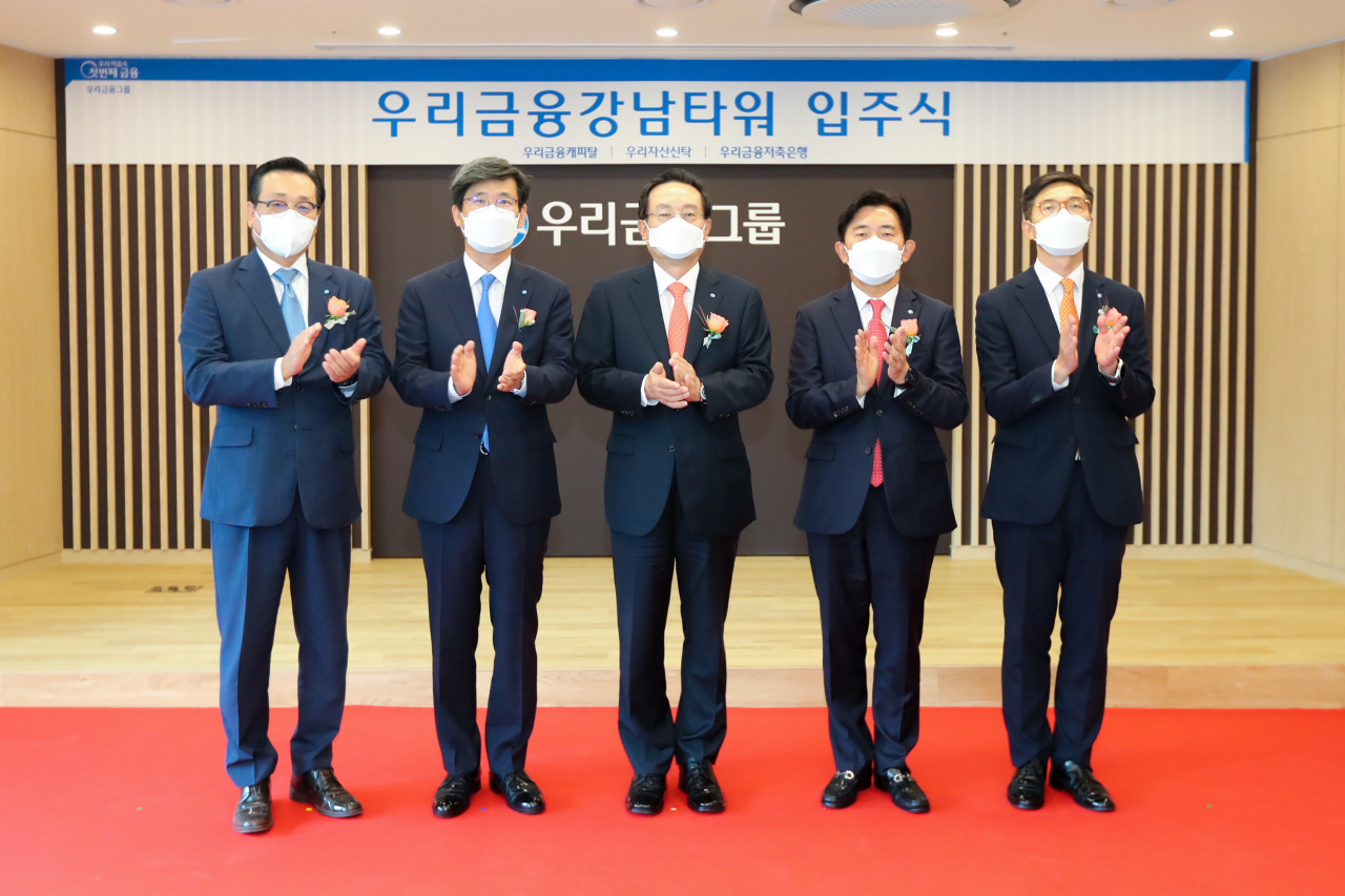 우리금융그룹은 지난 5일 서울 강남구 역삼동에 위치한 ‘우리금융강남타워’ 에서 비은행 자회사 3사 입주식을 가졌다. 손태승 우리금융그룹 회장은 이 자리에서 “그룹 4년 차인 내년에는 비은행 포트폴리오 확대와 기존 비은행 자회사 경쟁력 강화를 동시에 추진해 비은행부문을 그룹의 강력한 성장 동력으로 만들자”고 말했다. 왼쪽부터 우리자산신탁 이창하·이창재 공동대표, 손태승 우리금융그룹 회장, 박경훈 우리금융캐피탈 대표, 신명혁 우리금융저축은행 대표가 기념촬영을 하고 있다. [우리금융그룹]