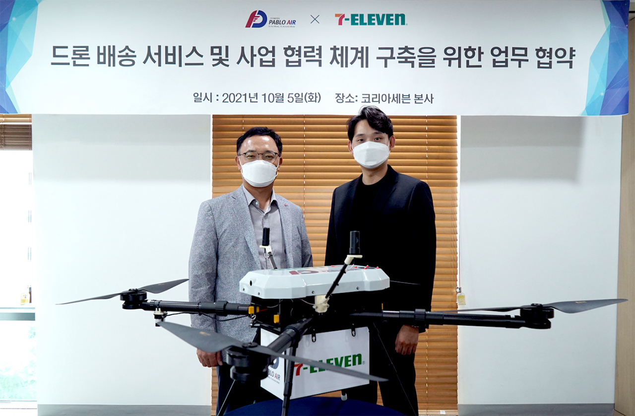 최경호(왼쪽) 세븐일레븐 대표이사와 김영준 파블로항공 대표이사가 MOU 체결 후 기념촬영을 하고 있다. [세븐일레븐 제공]