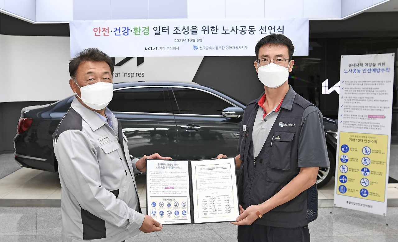 기아 대표이사 최준영 부사장(왼쪽)과 전국금속노조 기아자동차지부 최종태 지부장(오른쪽)이 지난 6일 열린 노사 공동 선언식에서 기념사진을 촬영하고 있다. [기아 제공]