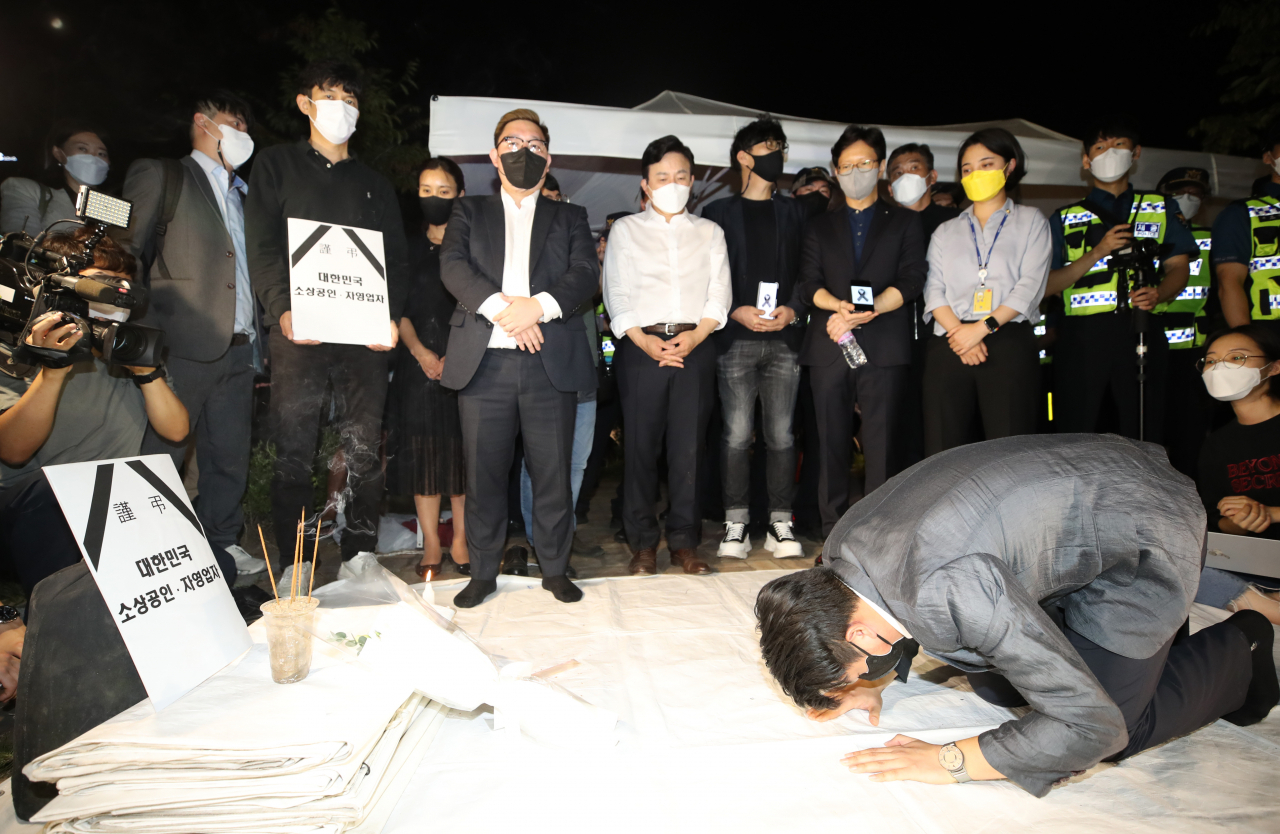 코로나19 대응 전국자영업비상대책위원회 소속 회원들이 지난달 16일 오후 서울 영등포구 지하철 국회의사당역 3번 출구 앞에 최근 생활고에 시달리다 세상을 떠난 자영업자들을 추모하고 정부에 영업제한조치 철폐를 촉구하는 분향소를 설치한 뒤 예를 갖추고 있다. [연합]