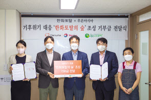 한화토탈 직원들이 지난 6일 고재광(가운데) 사단법인 푸른아시아 사무처장에게 사막화 방지 숲 조성 기부금을 전달하고 있다. [한화토탈 제공]