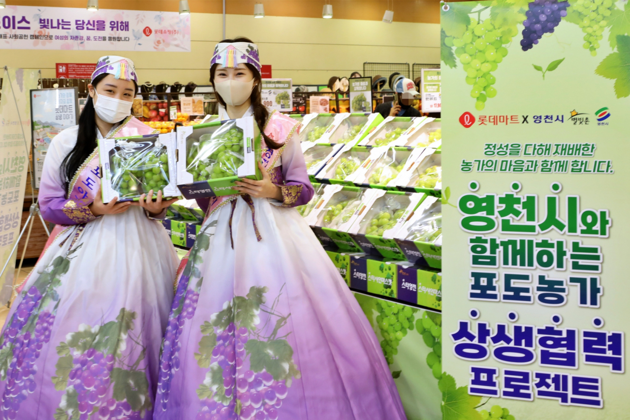 모델들이 샤인머스캣을 들고 롯데마트의 '영천시와 함께하는 샤인머스캣 대축제'를 홍보하고 있다. [롯데마트 제공]