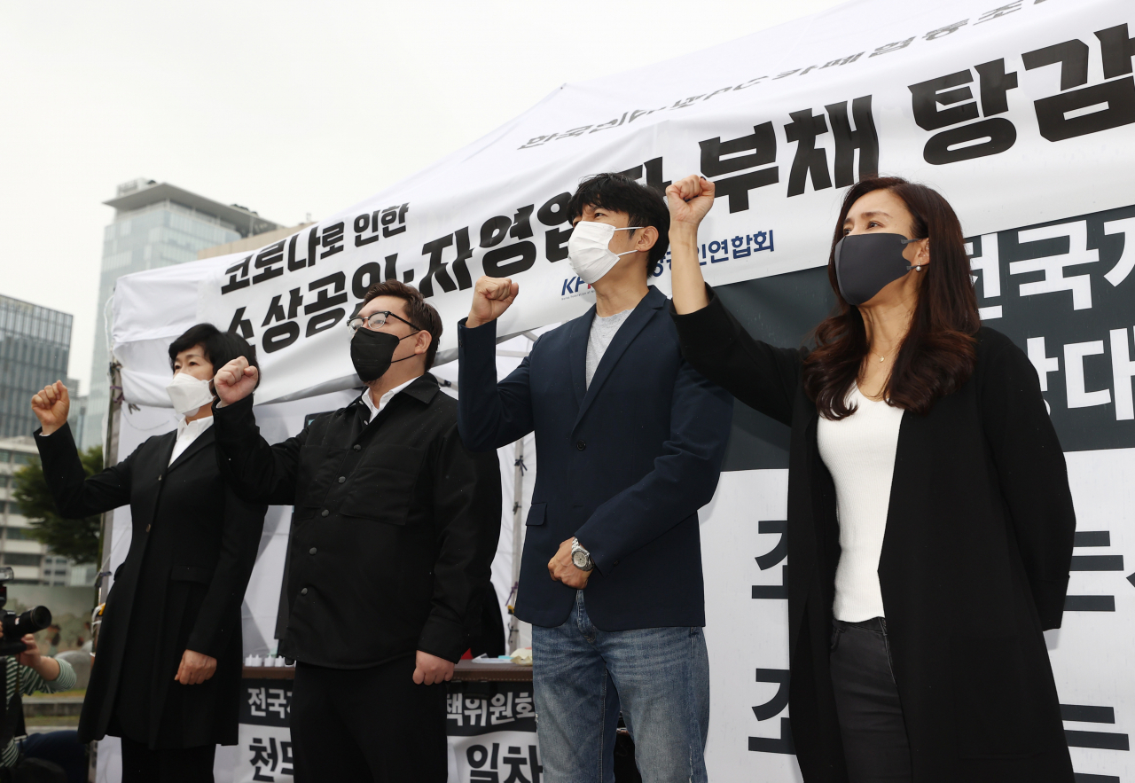 8일 정부서울청사 옆 세종로공원에 마련된 농성장에서 오세희(왼쪽부터) 소상공인연합회장과 코로나19 대응 자영업자비상대책위원회의 김기홍·이창호·조지현 공동대표가 소상공인, 자영업자 대책 관련 입장을 발표한 뒤 구호를 외치고 있다. [연합]