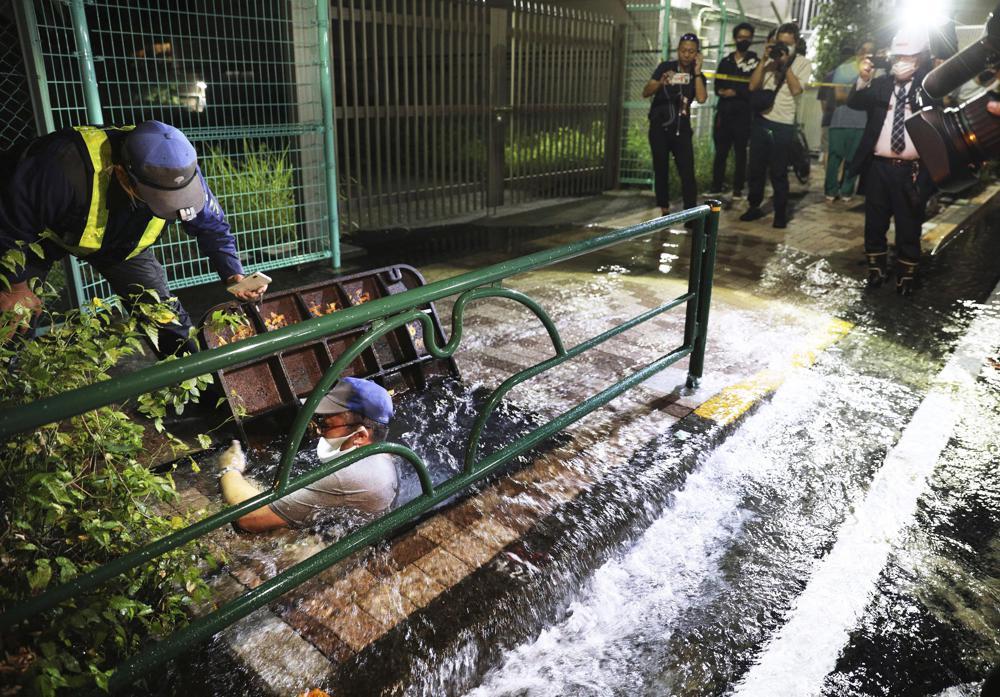 A road is soaked in water following an earthquake, in Tokyo, early Friday. A powerful earthquake shook the Tokyo area on Thursday night, halting trains and subways. (Kyodo News via AP)