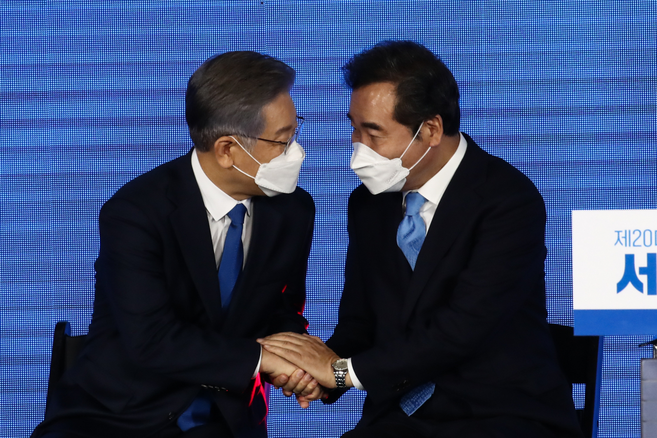 10일 오후 서울 송파구 올림픽공원 SK올림픽핸드볼경기장에서 열린 제20대 대통령선거 후보자 선출을 위한 서울 합동연설회에서 대선 후보로 확정된 이재명 경기도지사가 이낙연 후보와 손을 잡고 대화하고 있다. [연합]
