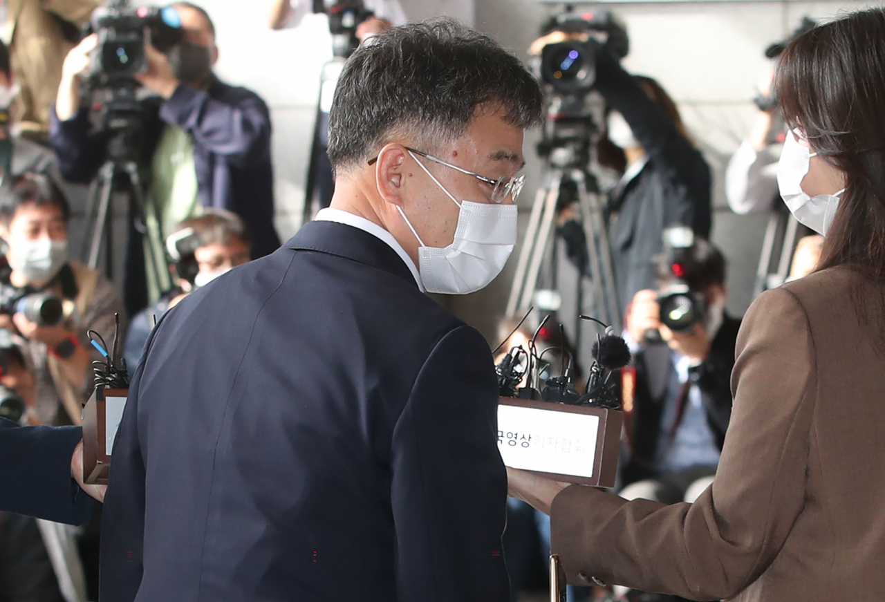 대장동 개발 로비·특혜 의혹의 핵심 인물인 화천대유자산관리 대주주 김만배 씨가 11일 오전 서울 서초구 서울중앙지검에 피의자 신분으로 출석하며 취재진에 둘러싸여 있다. [연합]