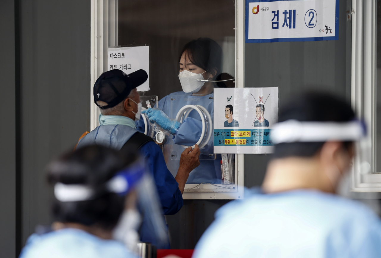 한글날 연휴 마지막 날인 11일 오전 서울역 광장 임시선별검사소에서 시민이 코로나19 검사를 받고 있다. [연합]