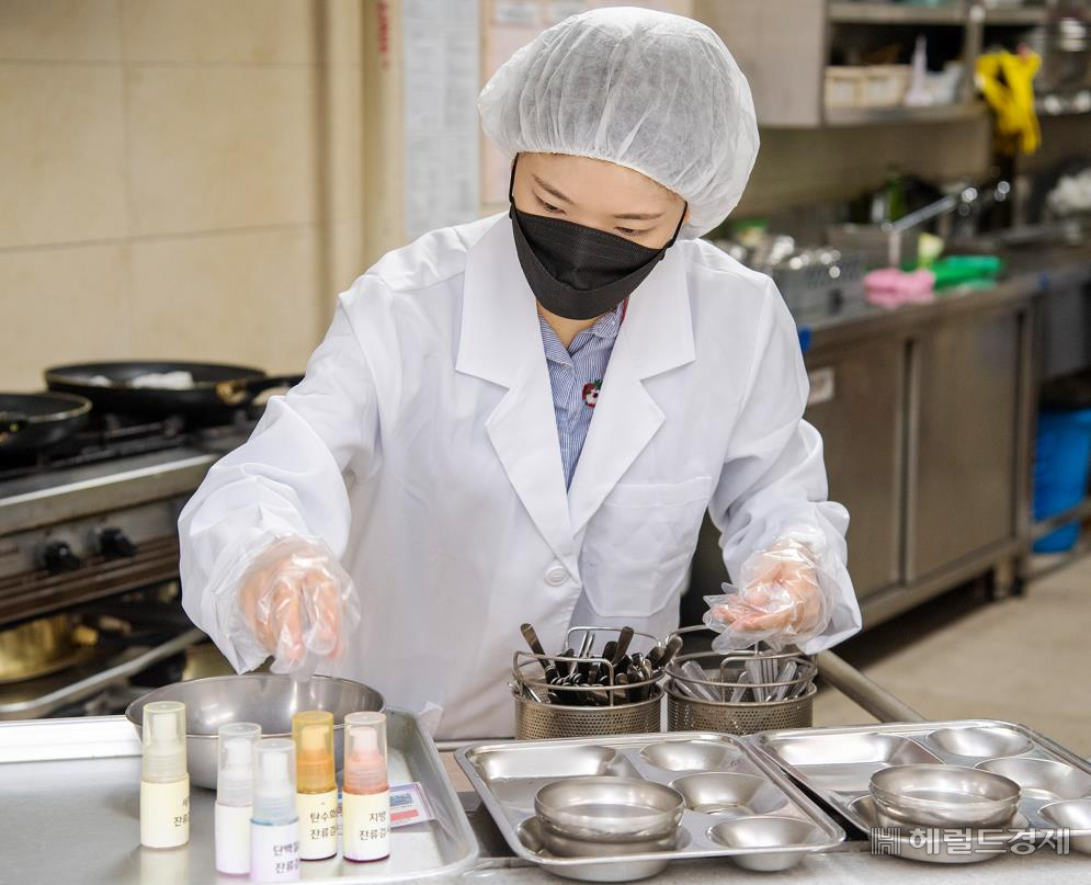 점검원이 용산구직장어린이집 급식실 식판 관리상태 확인하고 있다.