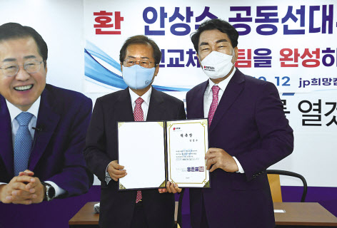 국민의힘 홍준표 대선 경선 후보가 12일 여의도 캠프사무실에서 지난 예비경선에서 탈락한 안상수 예비후보를 캠프의 공동선대위원장 겸 인천총괄본부장으로 영입하고 위촉장을 수여한 뒤 악수하고 있다. [국회사진기자단]