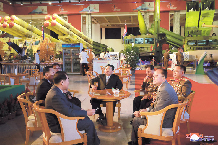 김정은 북한 국무위원장이 지난 11일 3대혁명전시관에서 개최된 국방발전전람회 ‘자위-2021’에 참석해 장창하 국방과학원장(김정은 위원장 오른쪽), 김정식 당 군수공업부 부부장(가장 오른쪽) 조용원 노동당 조직비서(앞줄 오른쪽) 등 간부들과 함께 맞담배를 피우고 있다. 북한은 실내 금연이지만, 김 위원장 등 7명 중 6명이 담배를 들고 있어 눈길을 끈다. [연합]