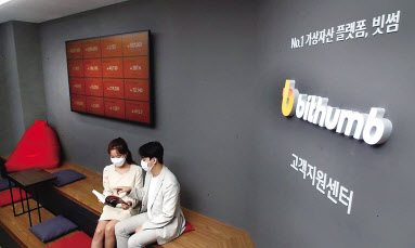 가상자산 투자자들이 빗썸 신설 고객센터에서 자료를 살펴보고 있다. [빗썸 제공]
