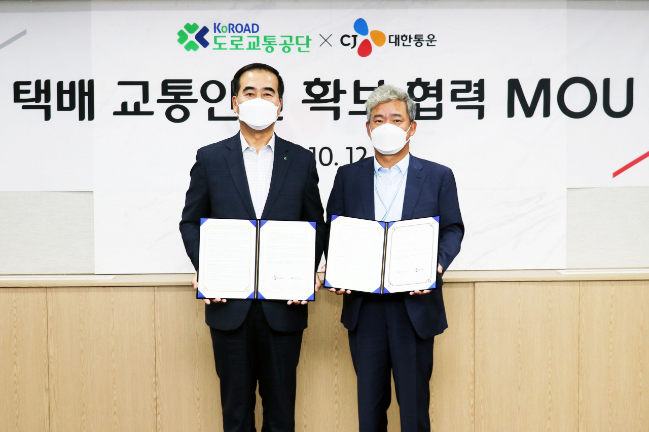 12일 CJ대한통운 신영수 택배·이커머스부문 대표(오른쪽)와 도로교통공단 이주민 이사장(왼쪽)이 업무협약을 체결하고 기념사진 촬영을 하고 있다. [CJ대한통운 제공]