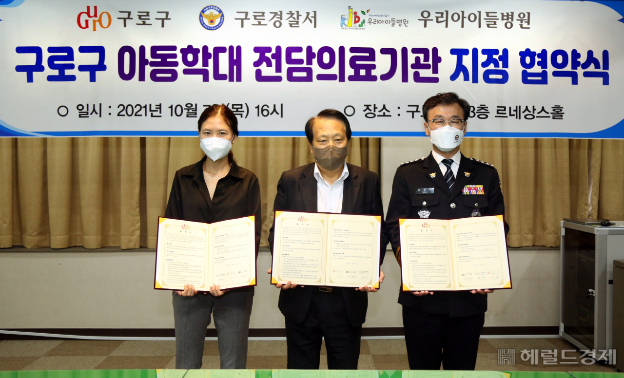지난 7일 구로구청에서 열린 아동학대 전담의료기관 지정 협약식에서 왼쪽부터 백정현 우리아이들병원장, 이성(가운데) 구청장, 임경우 구로경찰서장이 협약서를 들어보이고 있다. [구로구 제공]