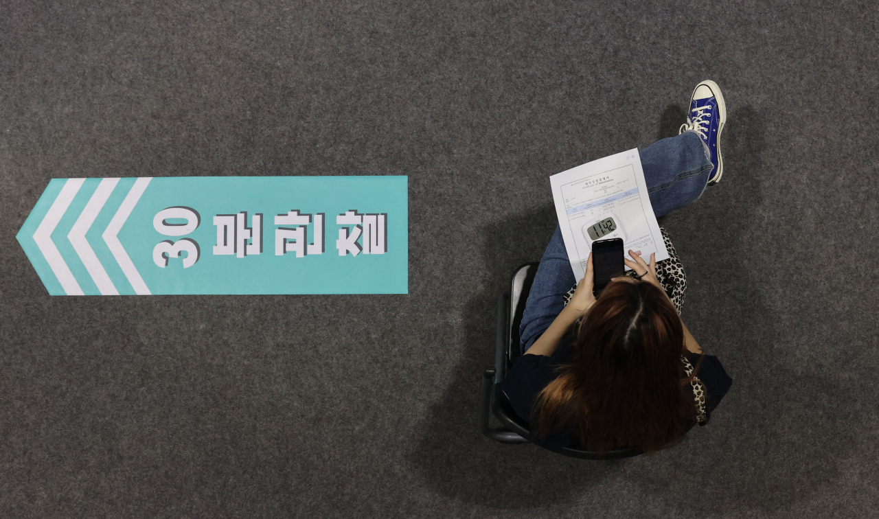 전체 인구 대비 신종 코로나바이러스 감염증(코로나19) 백신 접종 완료율이 60%%에 육박하고 있다. 사진은 한 백신접종 센터 백신을 접종한 뒤 이상반응을 점검하기 위해 대기하면서 휴대폰을 보고 있는 접종자의 모습. [연합]