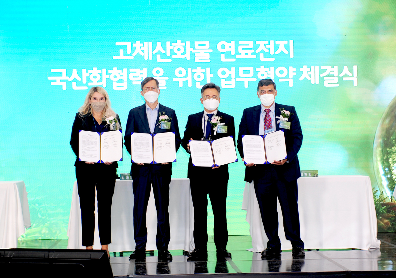 사진은 박경일 SK에코플랜트 대표이사(왼쪽 세번째), 셰얼린 무어(Sharelynn Moore) 블룸에너지 부사장 겸 마케팅 최고책임자(왼쪽 첫번째), 정재훈 한국수력원자력 사장(왼쪽 두번째), 랜디 아후자(Randy Ahuja) 블룸SK퓨얼셀 사장(왼쪽 네번째)이 협약서를 들고 기념촬영을 하고 있는 모습. [SK에코플랜트 제공]