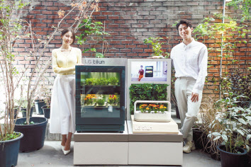 서울 성수동 ‘플라츠’에 위치한 팝업스토어 틔운하우스(tiiun haus: life with green)에서 14일 LG전자 소속 모델들이 신개념 식물생활가전 ‘LG 틔운(LG tiiun)’과 ‘LG 틔운 미니’를 체험하고 있다. [LG전자 제공]