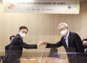 김준(오른쪽) SK수펙스추구협의회 환경사업위원회 위원장과 최병암 산림청장이 13일 업무협약을 체결한 뒤 주먹인사를 하고 있다. [SK 제공]