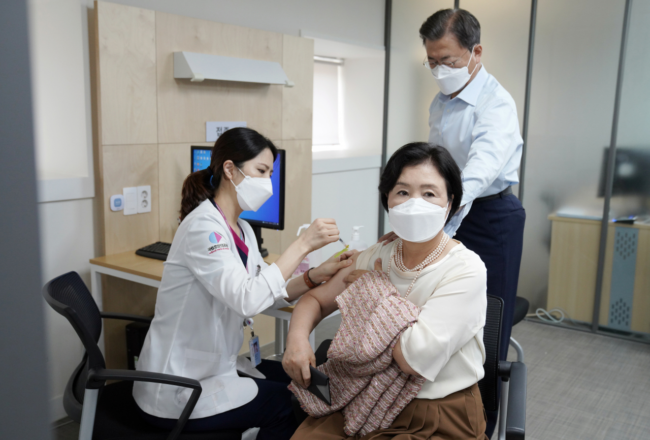 김정숙 여사가 15일 문재인 대통령과 서울 국립중앙의료원 코로나19 중앙예방접종센터에서 코로나19 백신 추가 접종을 받고 있다. 연합뉴스