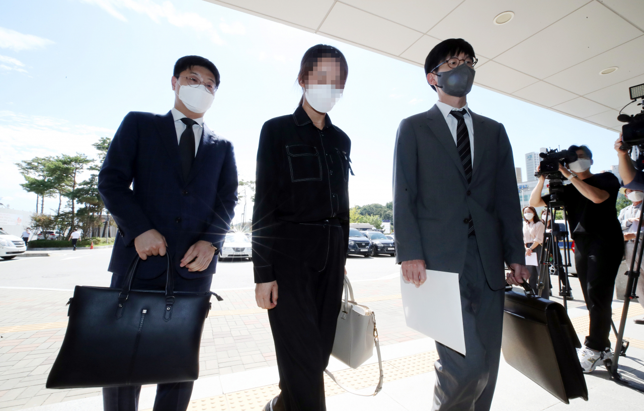 택배 노조원들의 집단괴롭힘을 호소하며 극단적 선택을 한 40대 김포 택배대리점주의 아내(가운데)가 지난달 17일 노조원 13명을 명예훼손, 모욕 혐의로 고소하기 위해 경기도 김포시 장기동 김포경찰서에 들어서고 있다. [연합]