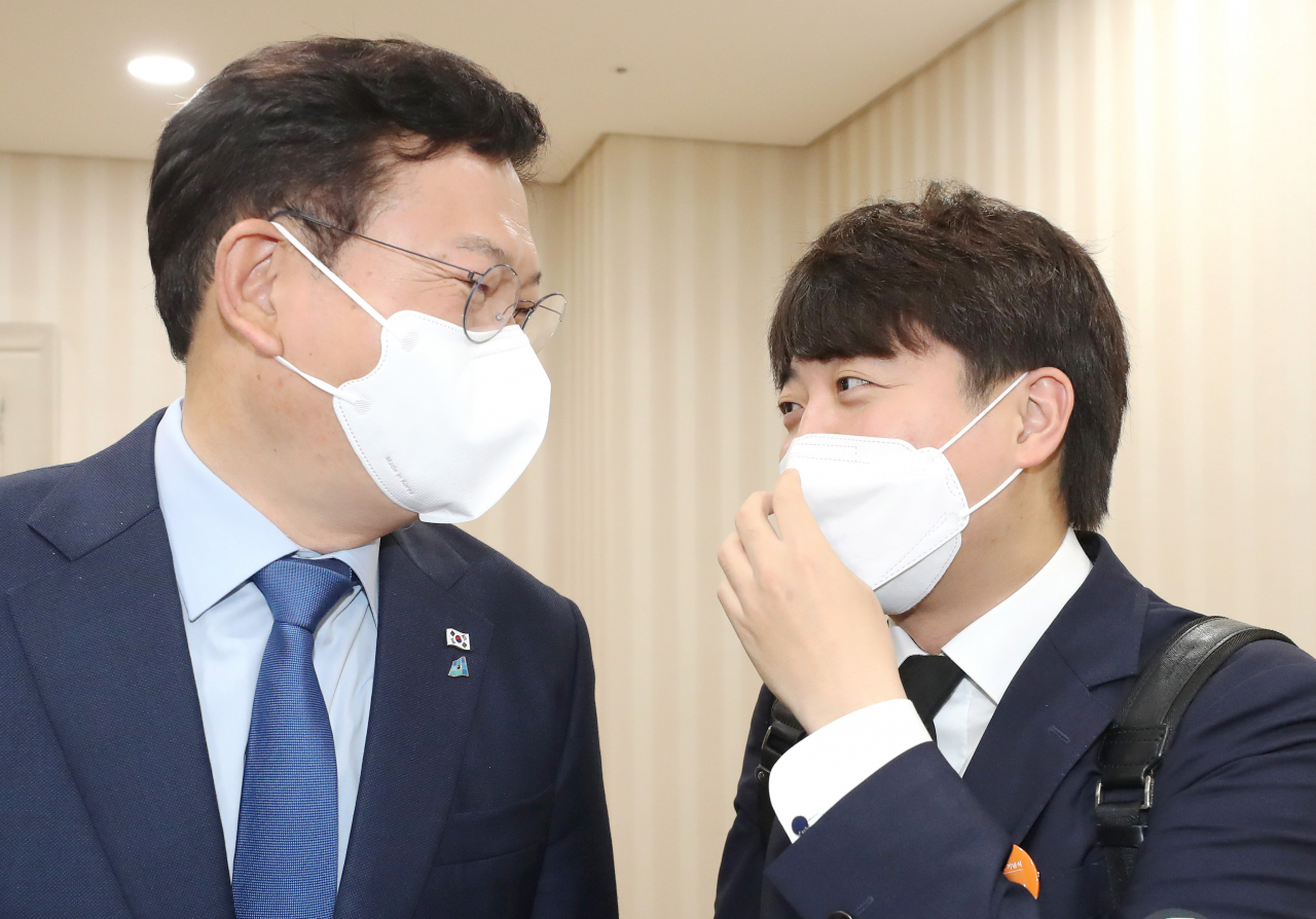 더불어민주당 송영길 대표(왼쪽)와 국민의힘 이준석 대표가 16일 오전 경남 창원시 3·15 아트센터에서 열린 제42주년 부마민주항쟁기념식에 참석하기 전 환담 장소에서 만나 대화하고 있다. [연합]