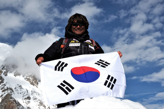 히말라야 브로드피크 정상에서 태극기를 펼쳐 보이고 있는 김홍빈 대장./광주산악연맹 제공