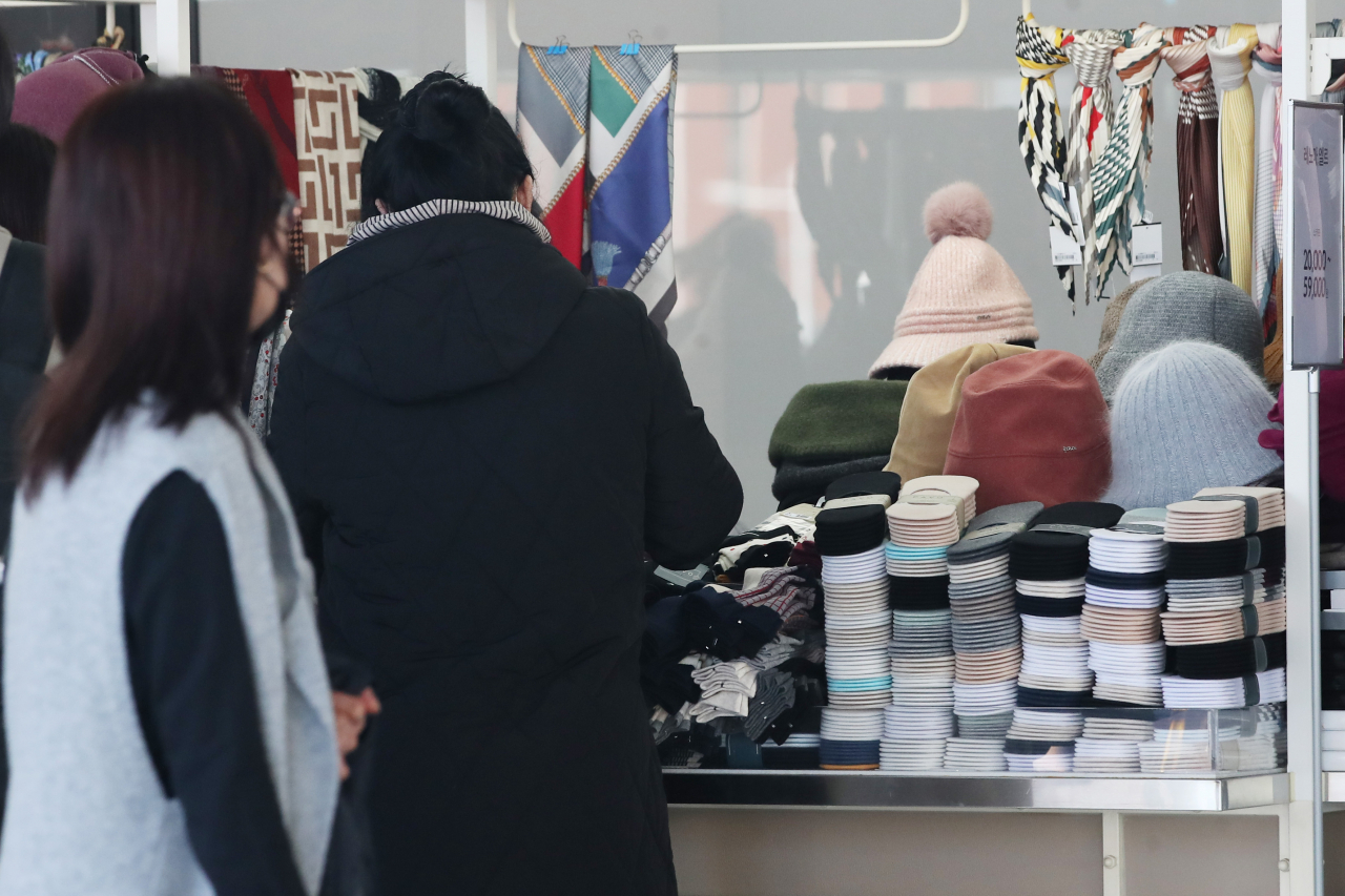 때 이른 추위를 보인 17일 서울의 한 쇼핑몰에서 시민들이 털모자 등 방한용품을 둘러보고 있다. [연합]