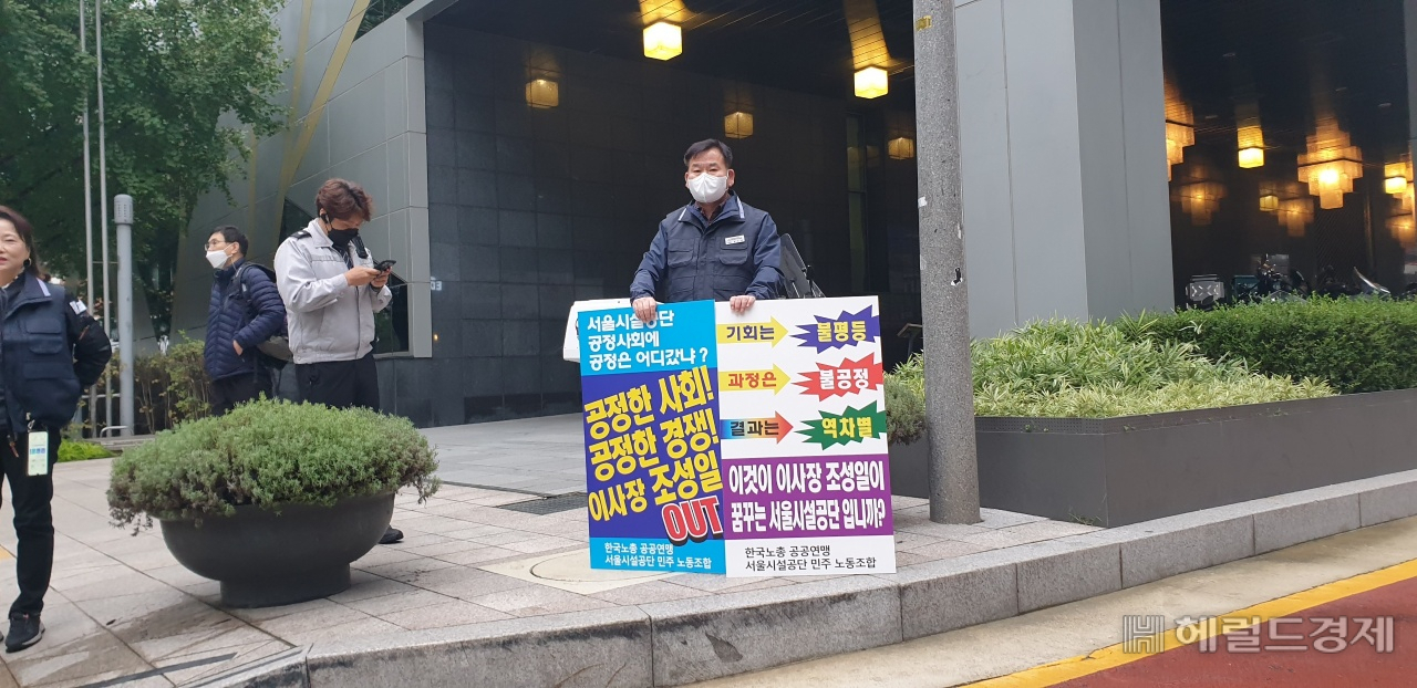 19일 서울시청사 앞에서 서울시설공단 민주노동조합 윤인영 위원장이 '이사장 조성일 OUT'이라고 적힌 피켓을 들고 있다.