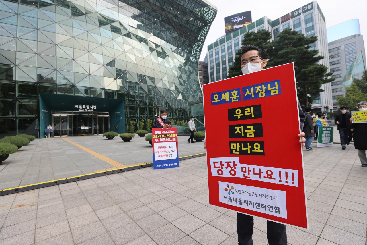 서울마을자치센터연합 회원들이 19일 오전 서울시청 앞에서 기자회견을 열고 서울시가 예고한 민간위탁 및 보조사업 구조 점검 및 마을자치 예산삭감 철회를 촉구하고 있다. [연합]