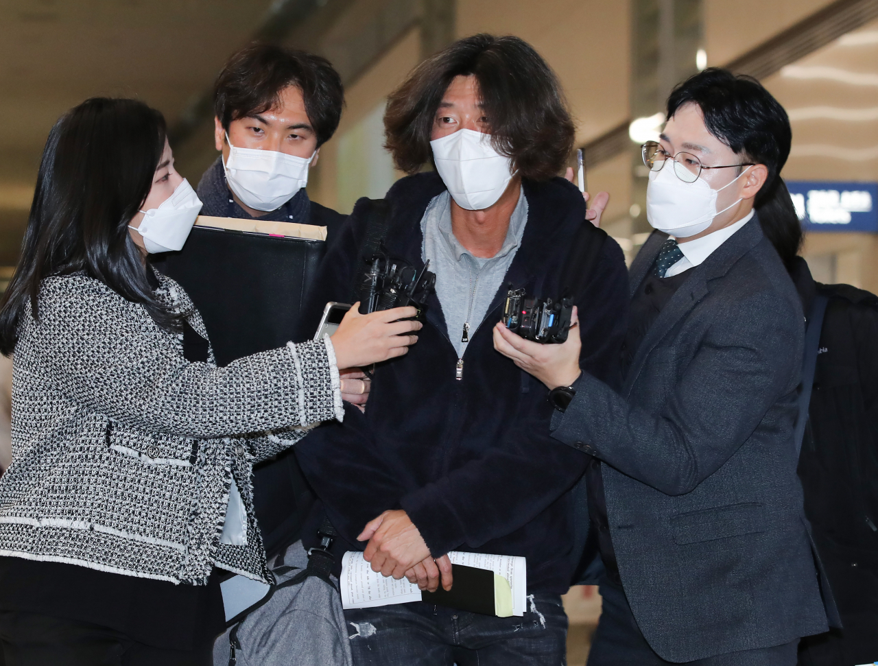 미국에 체류 중이던 대장동 개발 로비·특혜 의혹의 핵심 인물 남욱 변호사(왼쪽 세 번째)가 18일 오전 인천국제공항 제2여객터미널로 귀국해 검찰에 체포된 뒤 서울중앙지검으로 압송되고 있다. [연합]