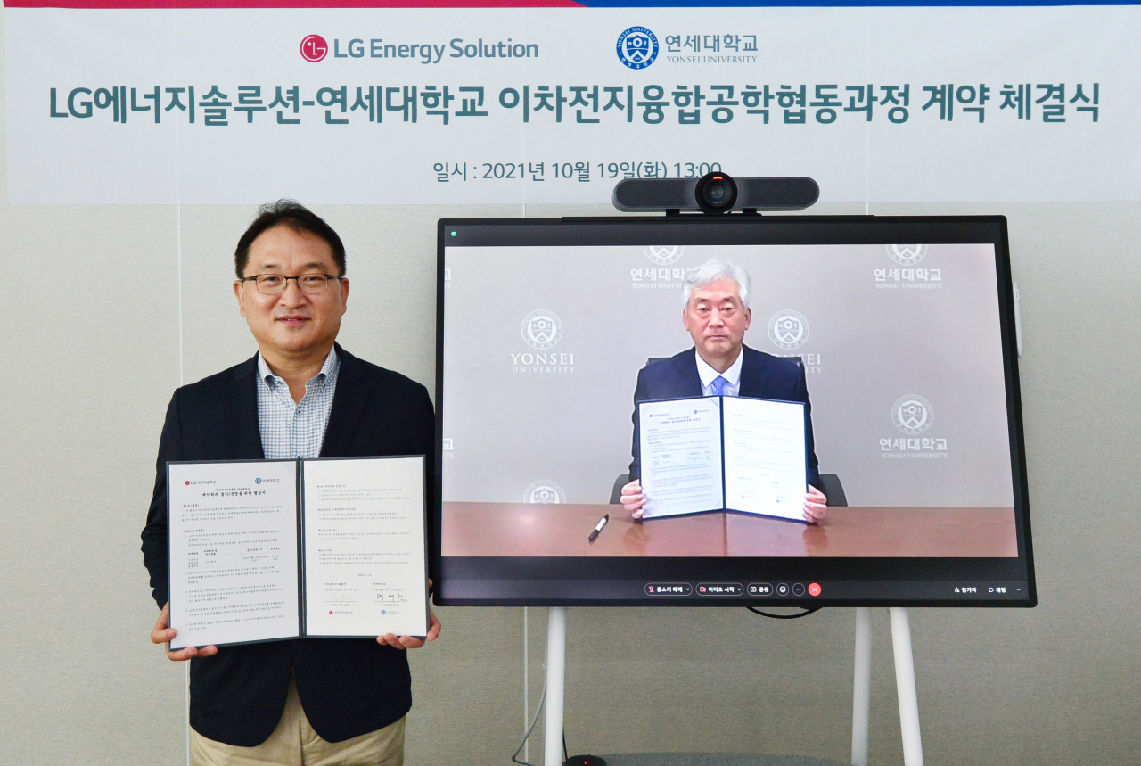 지난 19일 김흥식 LG에너지솔루션 부사장(왼쪽)과 연세대 명재민 공과대학장(화면)이 비대면 온라인 방식으로 ‘LG에너지솔루션-연세대학교 이차전지융합공학협동과정 계약 체결식’을 진행한 뒤 기념촬영을 하고 있다. [LG에너지솔루션 제공]