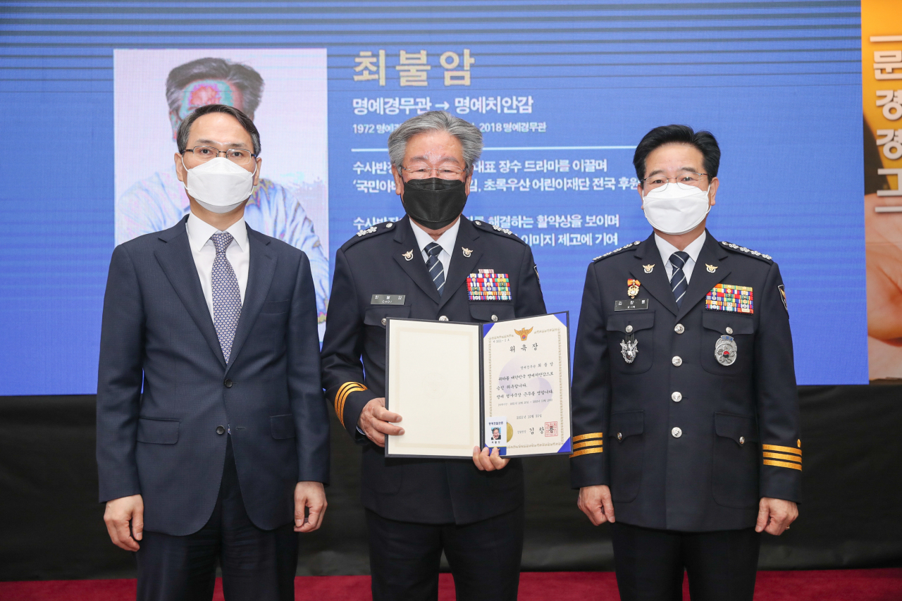 1970~1980년대 인기드라마 ‘수사반장’에서 각종 사건을 해결하는 반장 역할을 맡은 배우 최불암 씨가 20일 경찰청으로부터 초대 명예 형사국장으로 위촉됐다. 명예 경찰관으로 처음 위촉된지 50년 만에 명예 치안감으로 승진한 것이다. 사진은 이날 명예 경찰관 위촉식에서 최씨(가운데)가 김창룡 경찰청장(오른쪽), 남구준 경찰청 국가수사본부장과 함께 기념사진을 촬영하는 모습. [경찰청 제공]