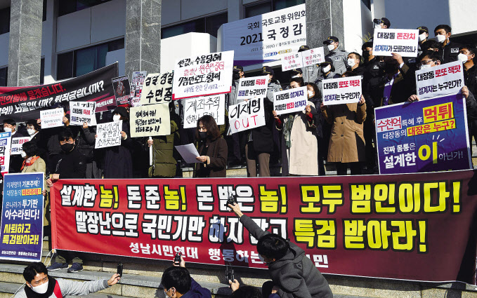 20일 국회 국토교통위원회의 경기도청에 대한 국정감사가 열린 경기 수원 경기도청 앞에서 시민단체와 대장동 주민 등이 성남 대장동 게이트 관련 플래카드와 손팻말을 들고 특검을 촉구하는 기자회견을 열고 있다. [국회사진기자단]