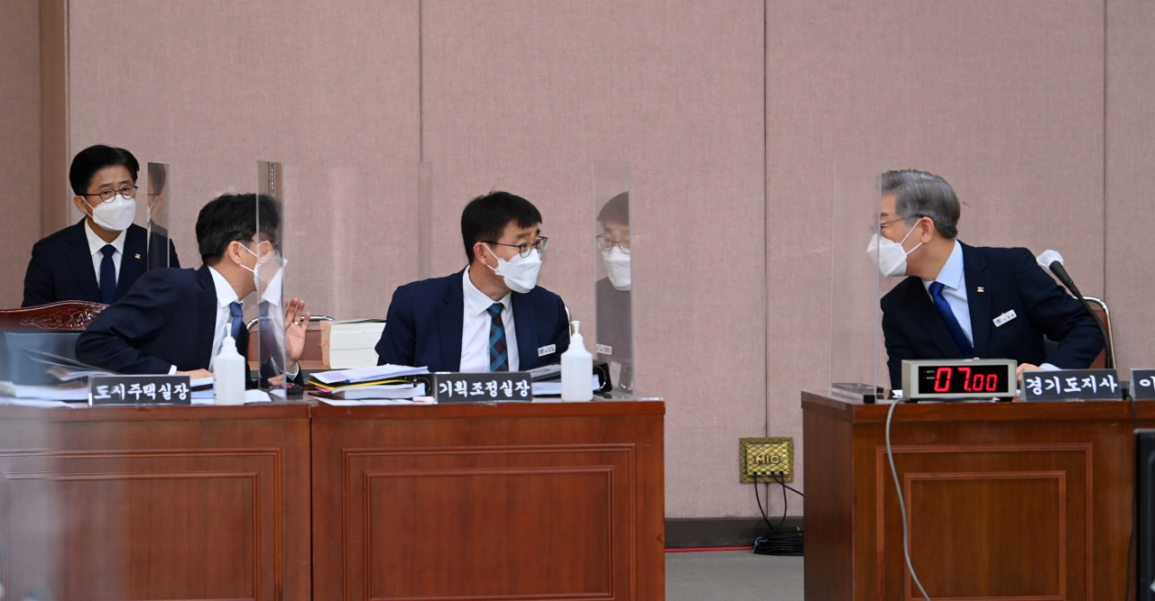 더불어민주당 대선후보인 이재명 경기지사가 20일 경기도 수원시 경기도청에서 열린 국회 국토교통위원회의 경기도에 대한 국정감사에서 도청 관계자와 이야기를 나누고 있다. [국회사진기자단]