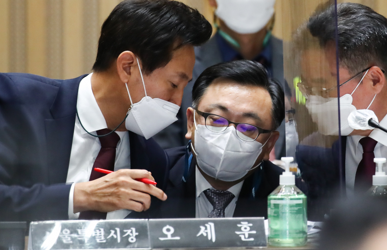 오세훈 서울시장이 20일 서울시청에서 열린 국회 국토교통위원회의 서울시 국정감사에서 김성보(가운데) 서울시 주택정책실장, 류훈 행정2부시장과 의논하고 있다. 연합뉴스