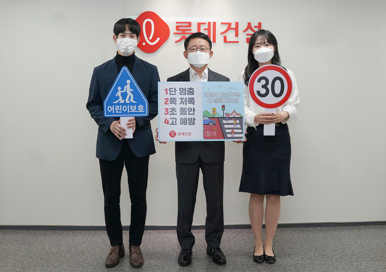 롯데건설 하석주 대표이사(가운데)와 임직원들이 20일 서초구 잠원동에 위치한 본사에서 '어린이 교통안전 릴레이 캠페인'에 동참하고 있다.[롯데건설 제공]