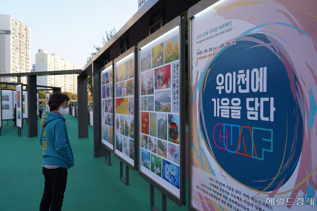 한 주민이 '우이천에 가을을 담다' 전시를 둘러보고 있다. [강북구 제공]